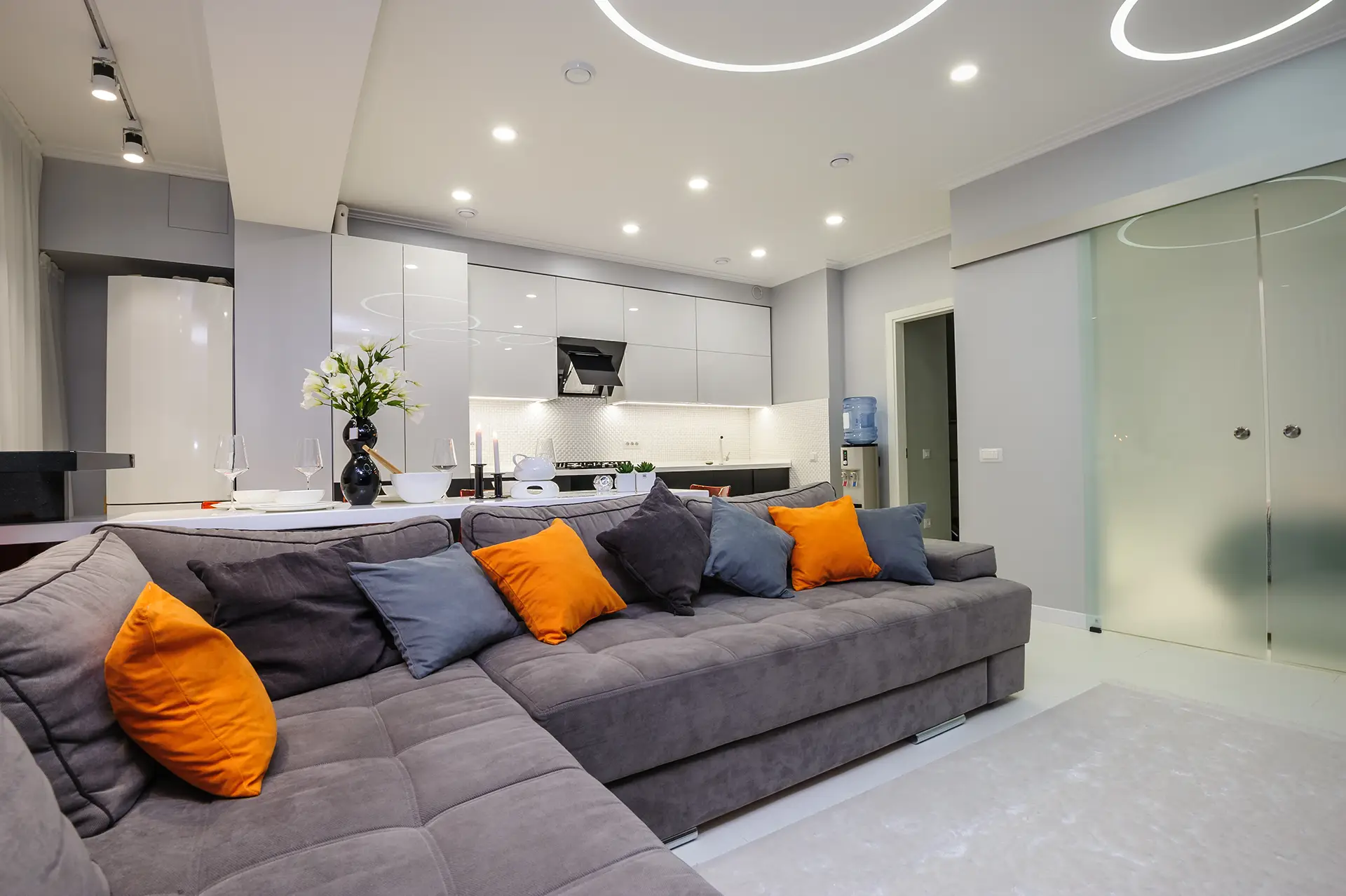 Sala com camadas de iluminação: spots, pendente e perfil de LED